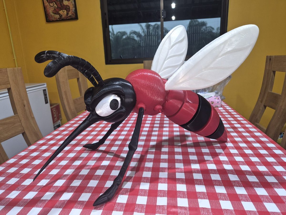 The giant mosquito printed and assembled on a red and white checked tablecloth